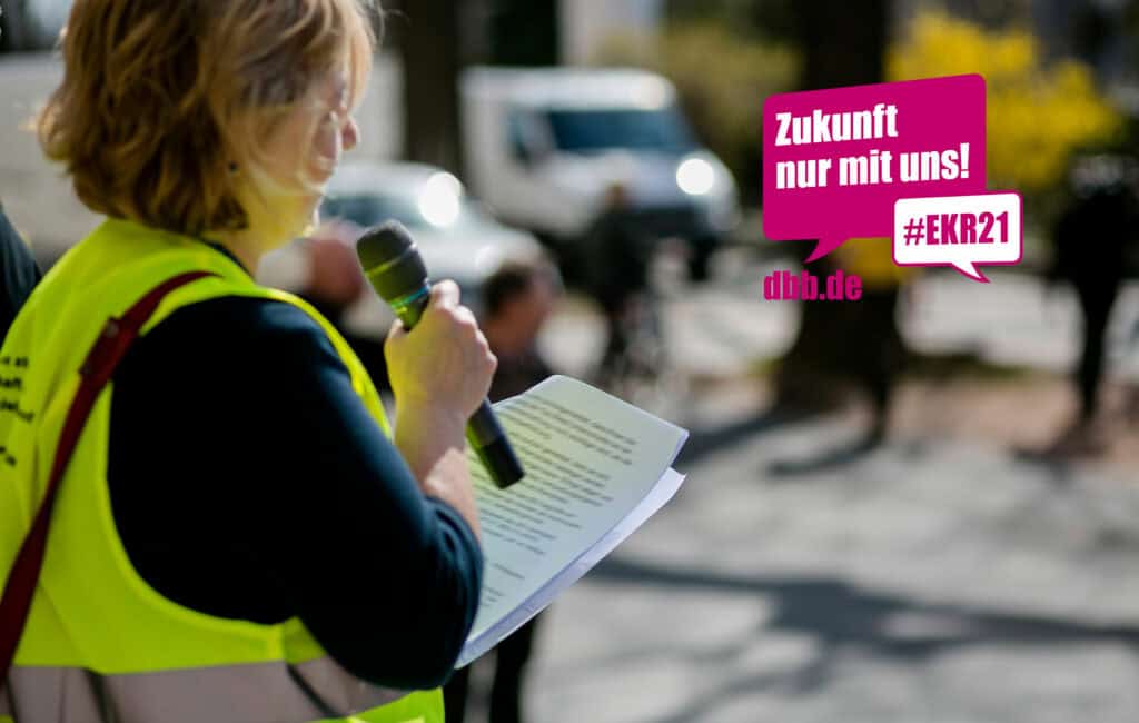 Frau spricht bei Demonstration für faire Löhne in Hessen.