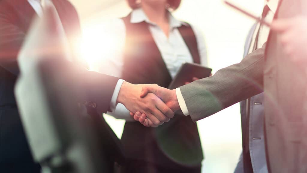 Handshake zwischen zwei Personen bei Personalvertretungsrecht-Verhandlung.