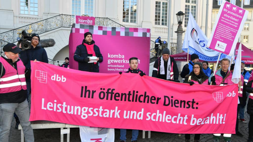 Demonstration bei Warnstreik in NRW mit Gewerkschaftsmitgliedern und Plakaten.