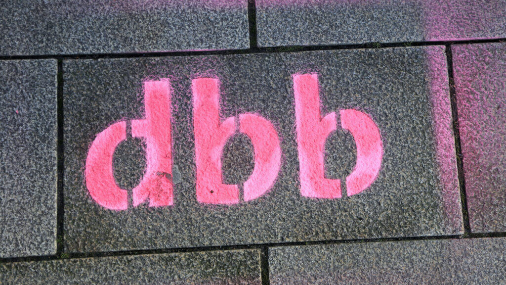 Pinkes Graffiti "dgb" auf Gehwegplatten während Warnstreik in Berlin.