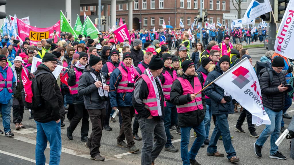 Menschen bei einer Demonstration in Berlin mit pinken Bannern und Plakaten.