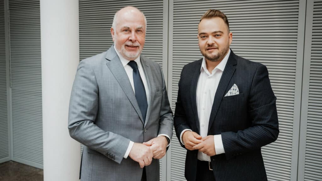 Zwei Männer in Anzügen bei einer Diskussion über den starken Staat in der Krise.