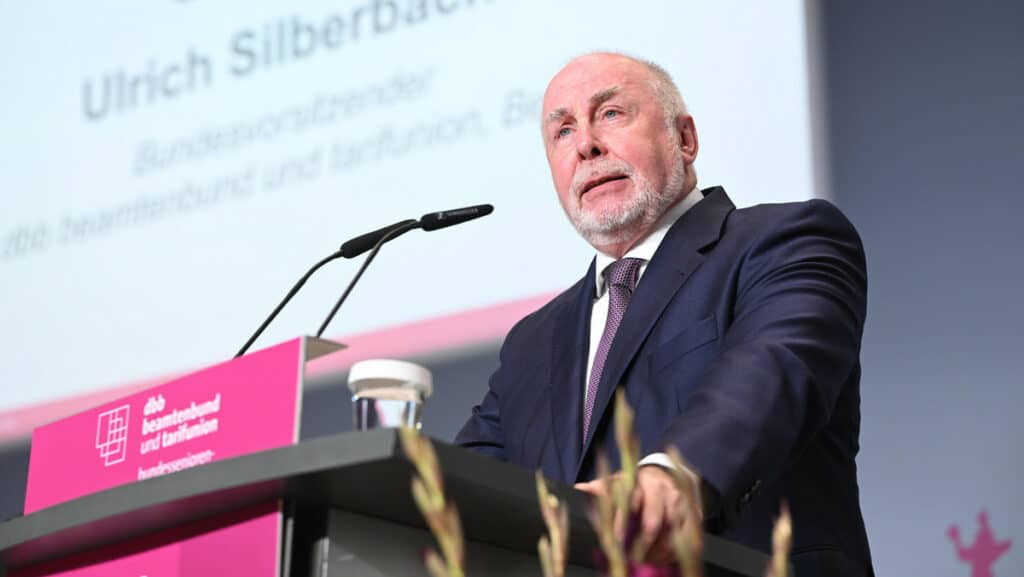 Politiker spricht bei VLWN-Konferenz, im Hintergrund Projektpräsentation.