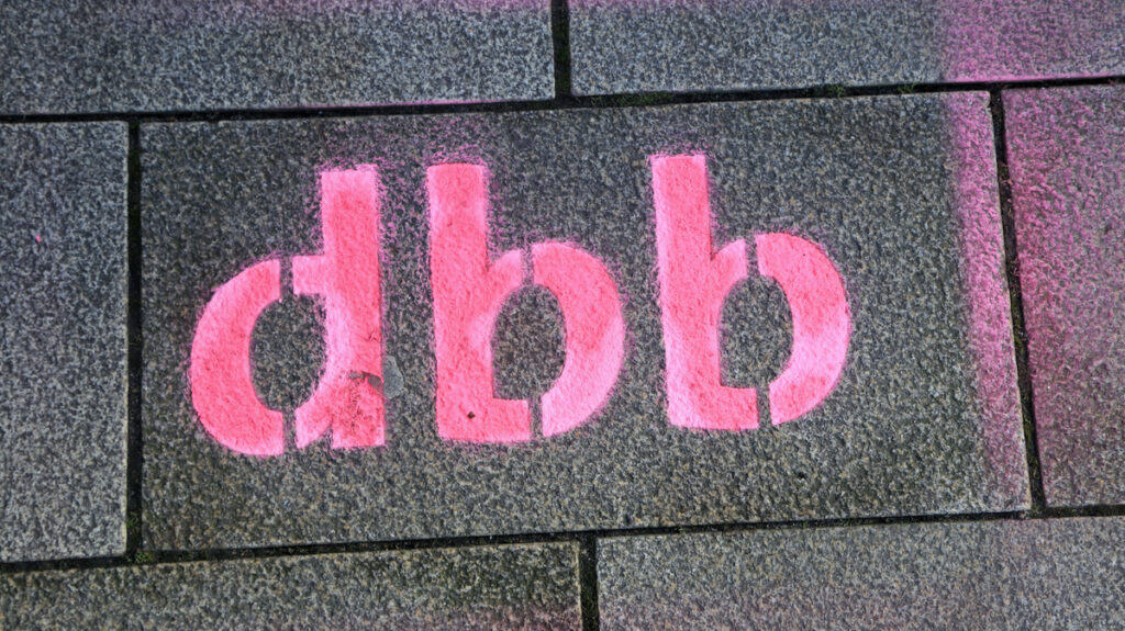 Graffiti "dbb" auf Pflasterstein, symbolisiert Streik und Protest.