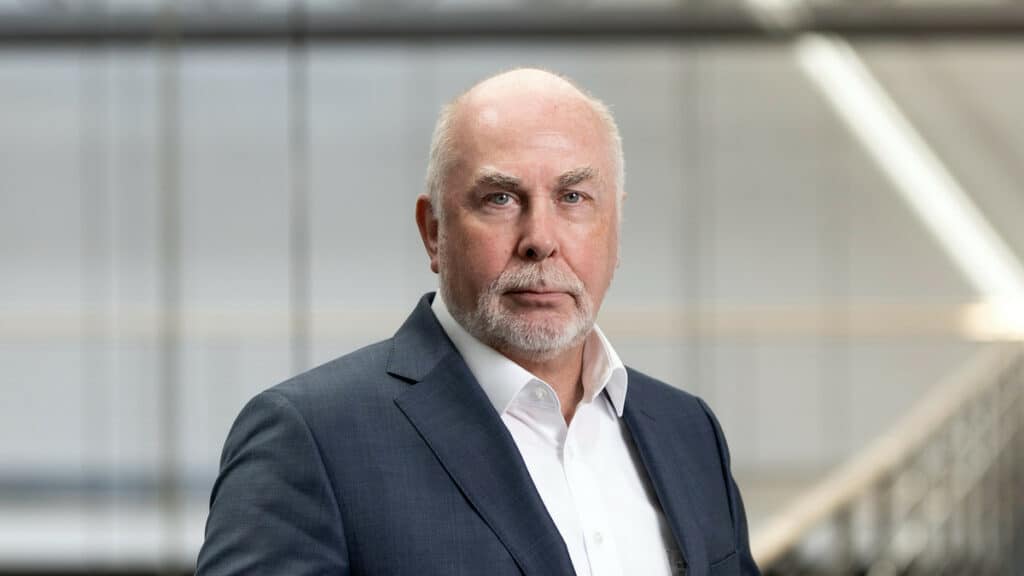 Mann in Anzug vor moderner Bürofassade, symbolisiert Personalmangel im öffentlichen Dienst.