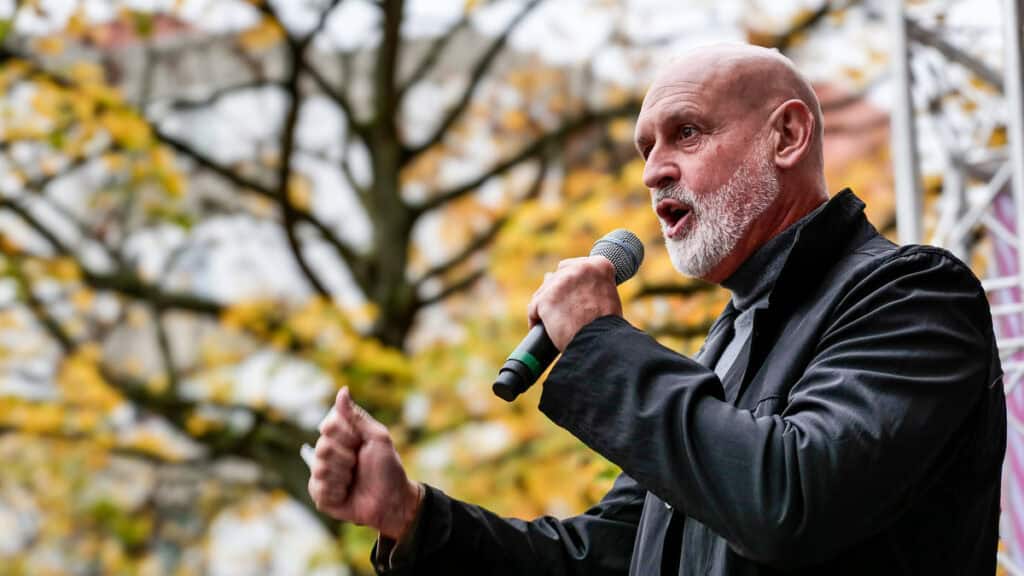 Mann bei Protest mit Mikrofon während Warnstreik im Herbst.