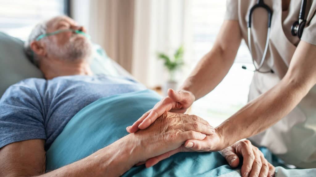 Pflegekraft betreut älteren Patienten in ländlicher medizinischer Grundversorgung.