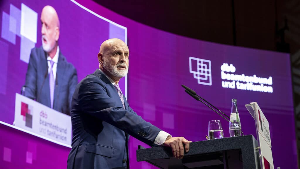 Mann spricht bei Konferenz über Investitionen in Straßen, Schulen und Polizei.