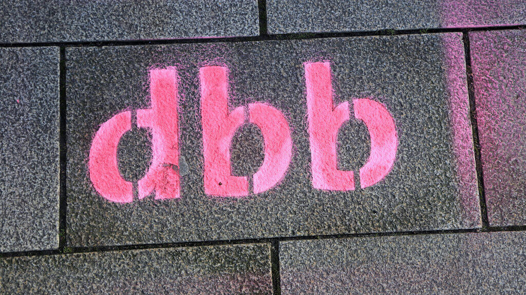 Graffiti mit "dgb" auf Gehweg, symbolisiert Arbeitsbelastung und Gewerkschaftsengagement.