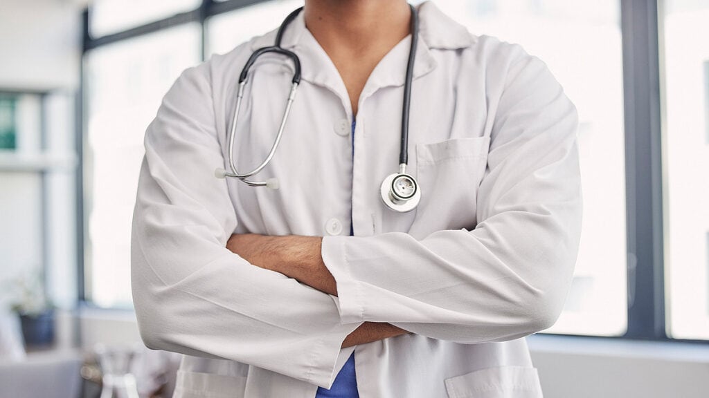 Ärztin mit Stethoskop in Klinik, Fokus auf Gesundheitsreform.