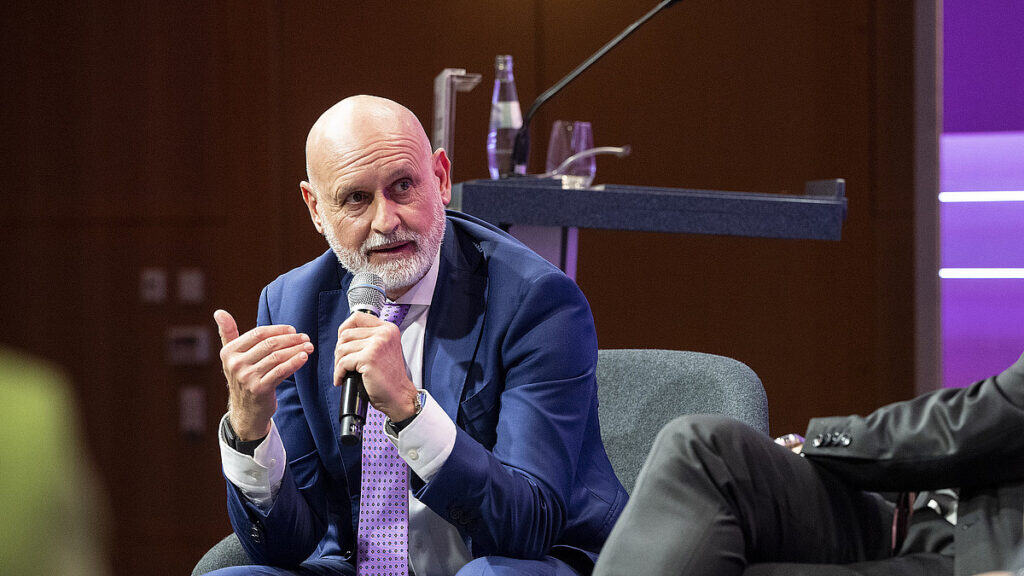 Mann diskutiert bei Konferenz über digitale Gesetzgebung und technologische Lösungen.