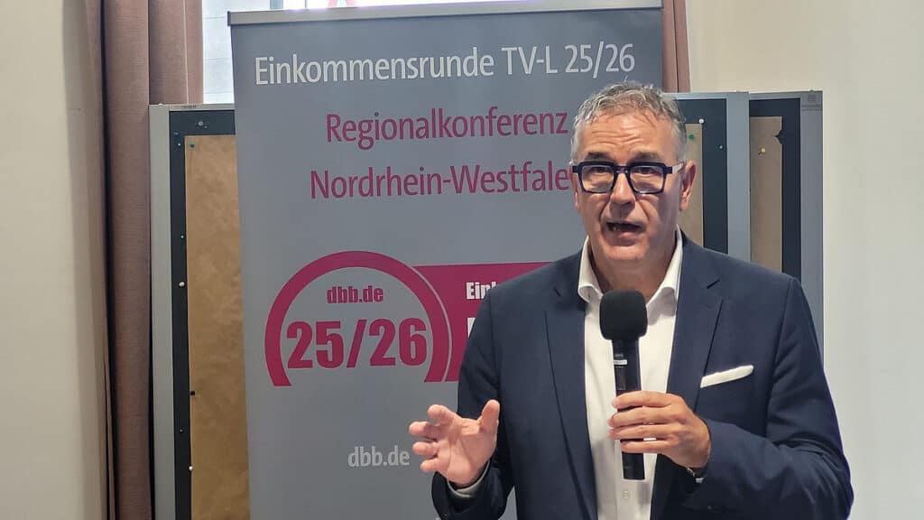 Barrierefreies Bild eines Mannes, der bei der Einkommensrunde in Nordrhein-Westfalen spricht.