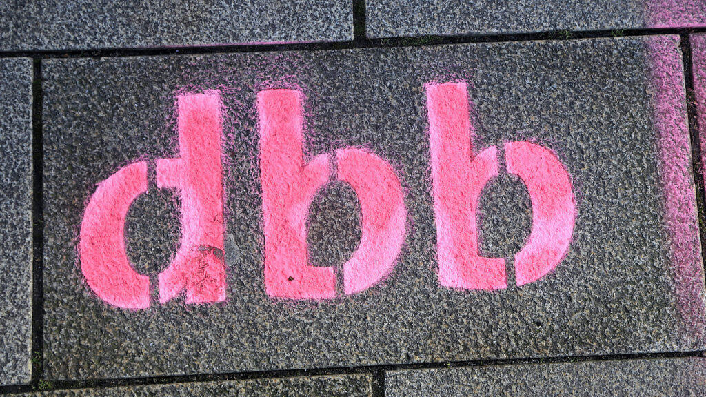 Graffiti mit "dbb" auf Steinmauer, symbolisiert Gewerkschaftsarbeit.
