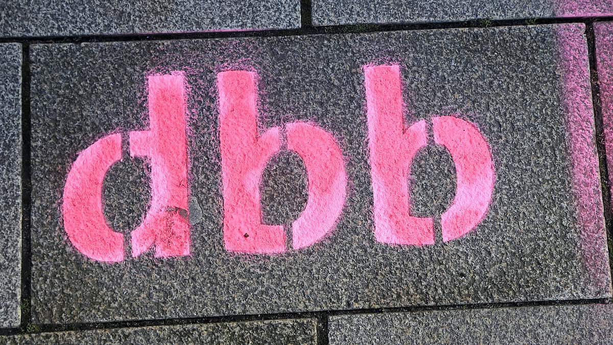 Digitales Rathaus-Symbol in Pink auf Steinmauer.