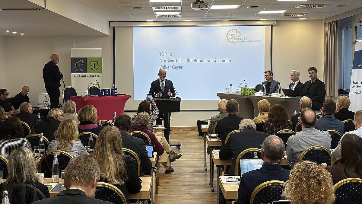 Konferenz zum Bildungssystem mit Redner und Publikum, Fokus auf Bildungspolitik.