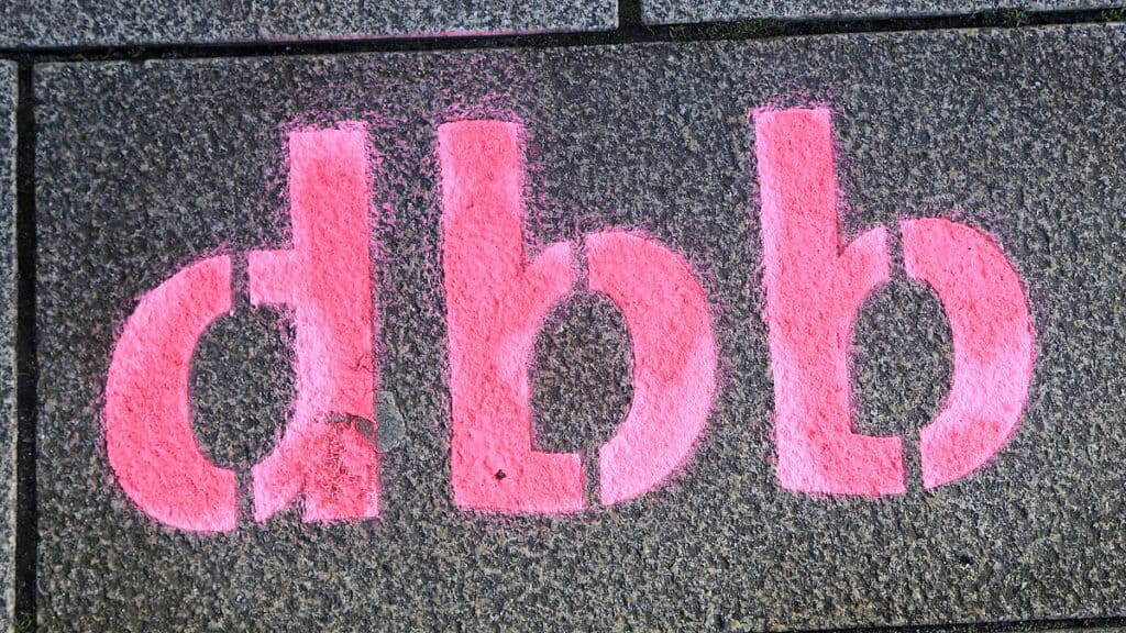 Graffiti mit den Buchstaben "d.b.b" auf einer Wand, politische Botschaft.