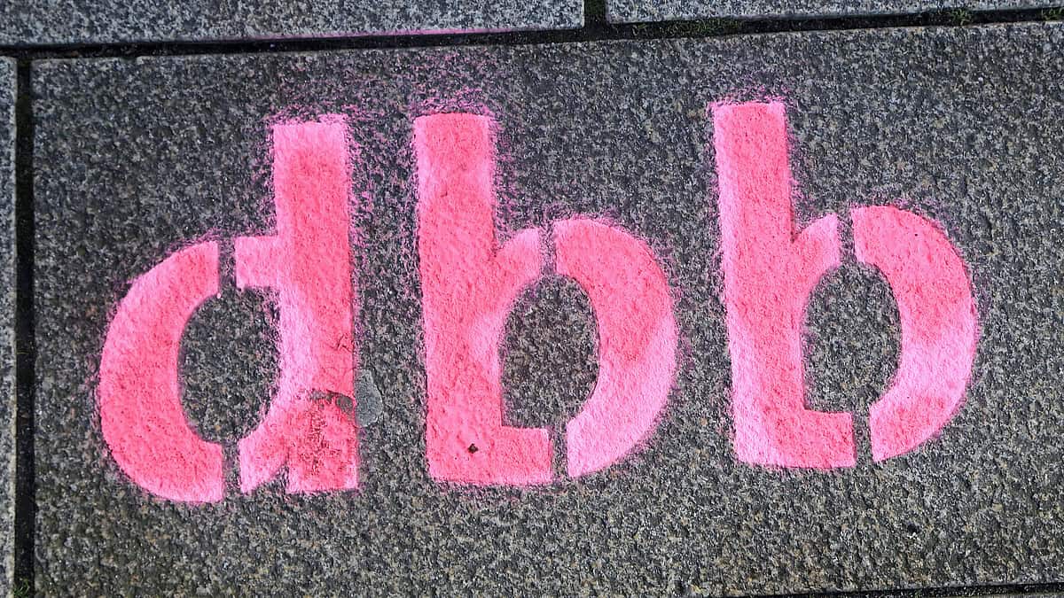 Graffiti mit den Buchstaben "d.b.b" auf einer Wand, politische Botschaft.