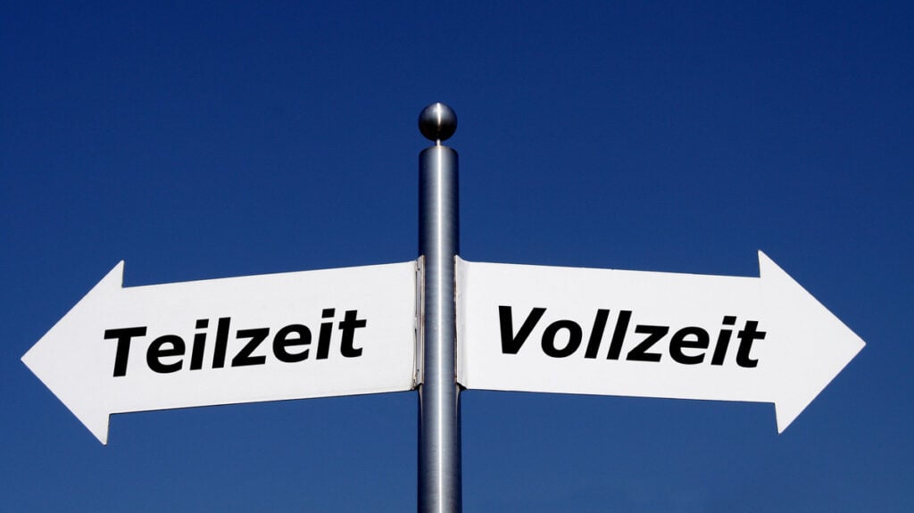 Wegweiser mit "Teilzeit" und "Vollzeit" gegen blauen Himmel, symbolisiert Arbeitszeitwahl.