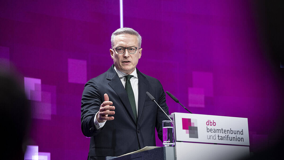 Politiker bei einer Rede auf einer Veranstaltung, Hintergrund in Lila.