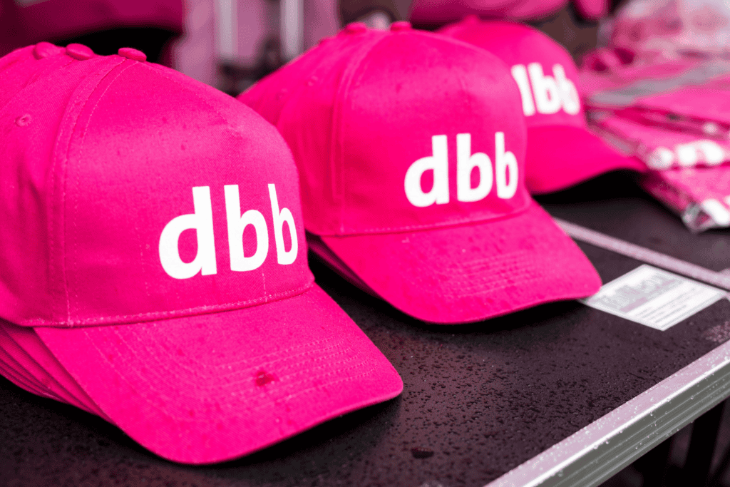 Dbb Pink Caps mit Logo, symbolisieren faire Bezahlung im öffentlichen Dienst.