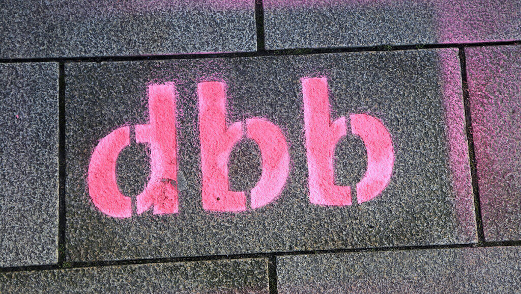 Pinke Graffiti-Schrift auf Ziegelmauer mit "dgb".
